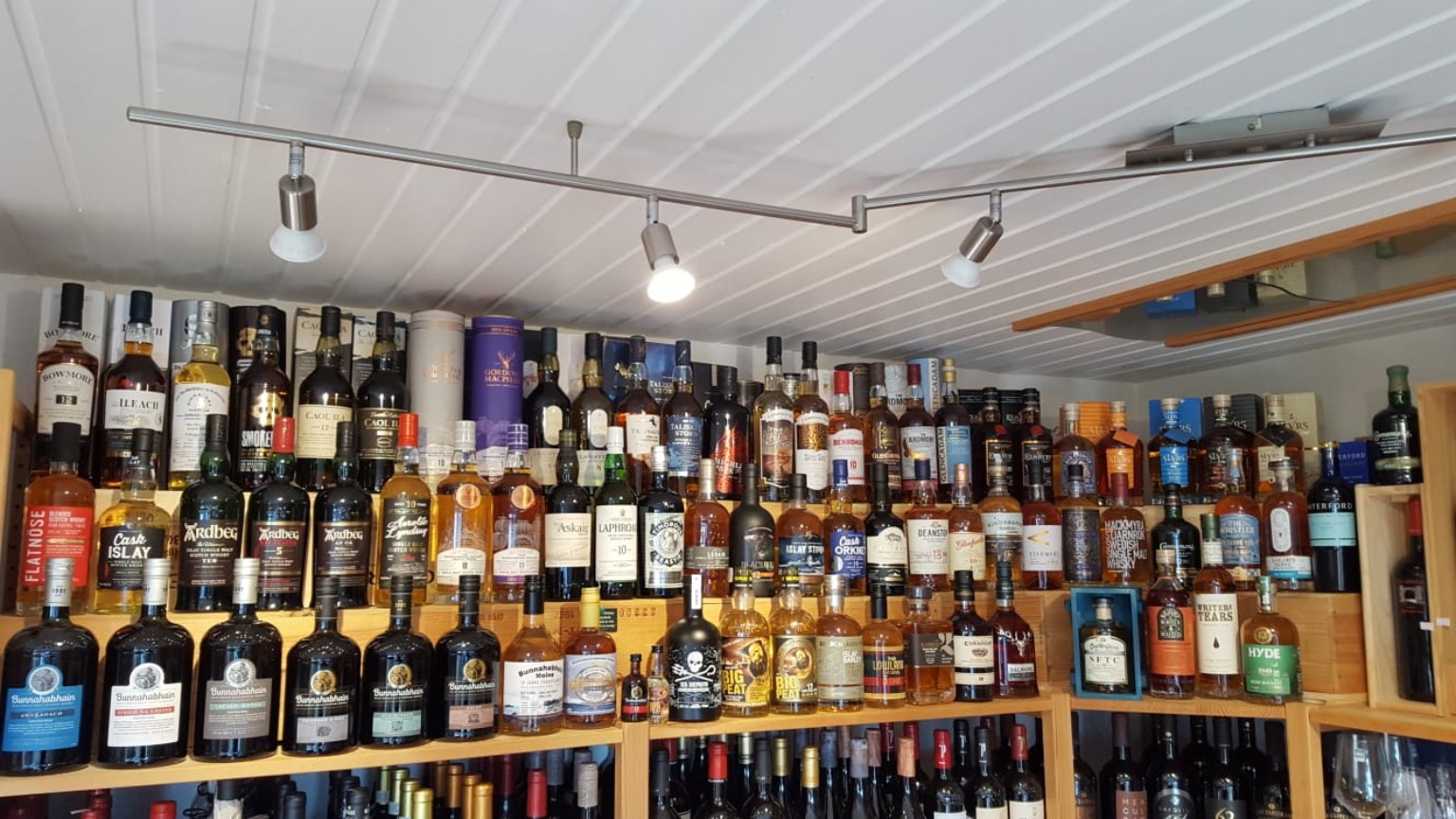 Eine große Auswahl an Whiskys in den Holzregalen des Weinhandels